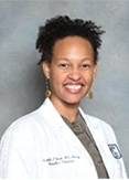 Michelle Morse has short coily black hair. She is wearing a white coat.