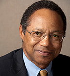A. Eugene Washington has very short black hair and glasses. 