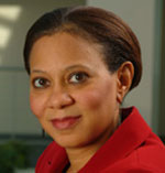 Lisa Cooper has short brown hair and is wearing a red shirt.
