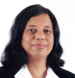 Bernadette Theodore-Gandi has medium-length wavy black hair. 