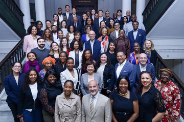 A large group alumni fellows pose for a photo on the steps in Gordon Hall.