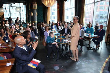 Joan Reede stands amongst a bunch of filled tables in Grace By Nia.