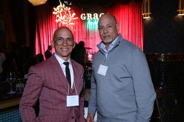 Two alumni fellows stand in front of the Grace By Nia stage.