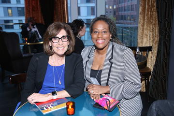 Two alumni fellows smile as they sit at the table in Grace By Nia. 