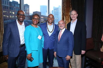 Alumni fellows pose in front of a large window in Grace By Nia.