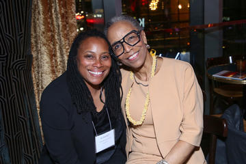 An alumni fellow sits next to Joan Reede.