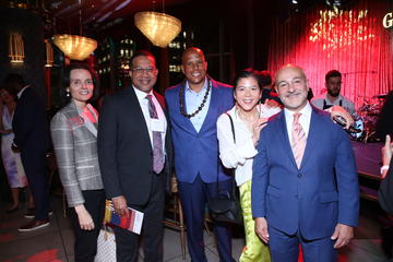 Several fellows stand under the lights and near the stage at Grace By Nia.