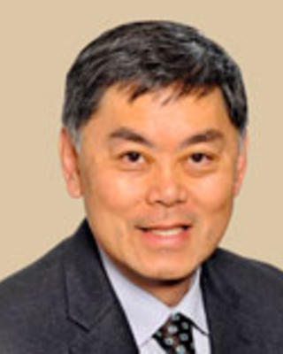 Benjamin Chu has short black hair and is wearing a suit.