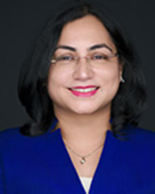 Divya Upadhyay has shoulder-length black hair and is wearing a blue blazer.