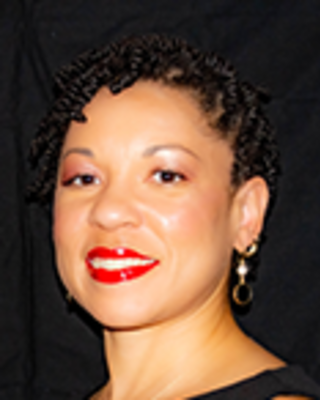Mary Fleming has short hair twists and is wearing a sleeveless black dress.