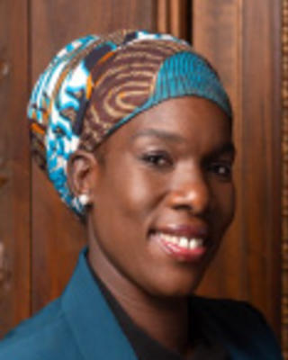 Nana Afoh-Manin is wearing a patterned blue headscarf and blue blazer.