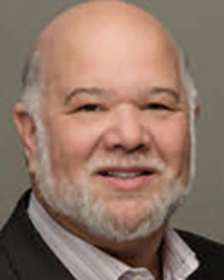 Alonzo Plough is mostly bald with white facial hair.