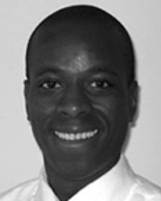 Jean Raphael is a bald man wearing a white shirt and tie.