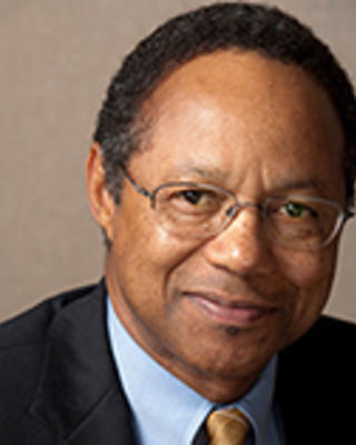 A. Eugene Washington has very short black hair and glasses. 