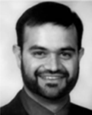 Mas'ood Cajee has short black hair and facial hair.