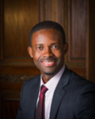 Asare Christina has short black hair and is wearing a suit.