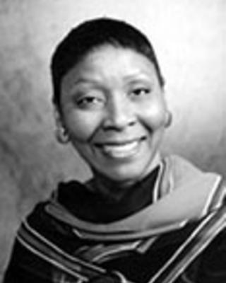 Cynthia Hodge has cropped black hair. She is wearing a patterned scarf around her neck.