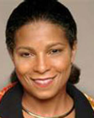 Risa Lavizzo-Mourey has black hair tied back. She is wearing a black and orange printed shirt.