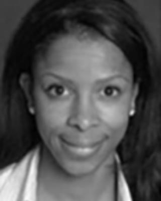 Yvette Marquis has long straight black hair and is wearing a white shirt.