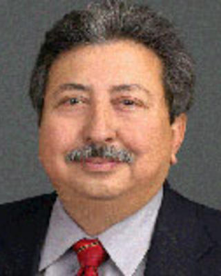 Fernando Sanchez Mendoza has short gray hair and a moustache. He is wearing a suit.