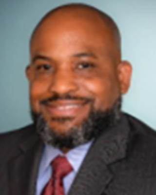 Muntu Davis is a bald man with a black/gray beard.