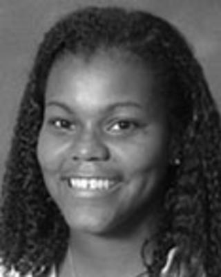 Kima Taylor has medium-length curly hair.