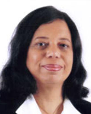 Bernadette Theodore-Gandi has medium-length wavy black hair. 