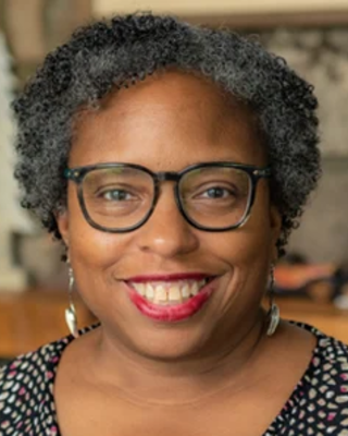 Kimberlee Wyche-Etheridge has short curly gray hair.