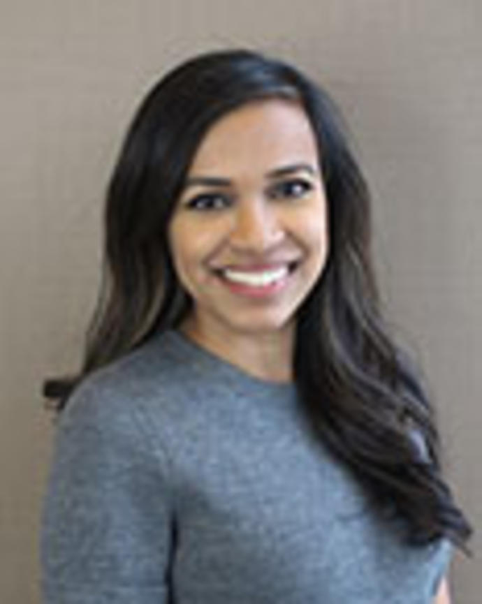 Mehedia Haque has long straight black hair. She is wearing a gray knit shirt.