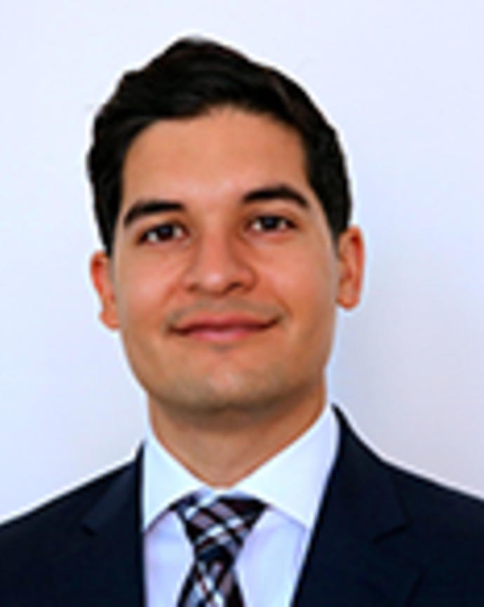 Daniel Gonzalez has short black hair and is wearing a suit.