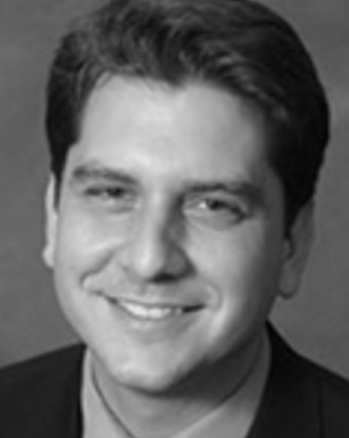 Eduardo Azziz-Baumgartner has short dark hair and is wearing a suit.