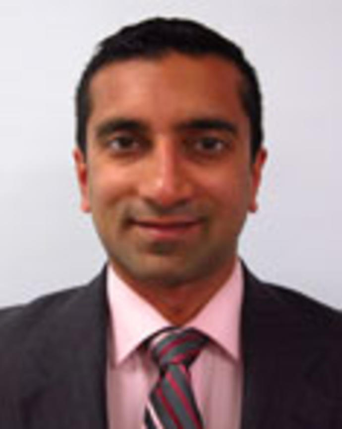 Jay Bhatt has short black hair. He is wearing a pink shirt, pink patterned tie, and black blazer.
