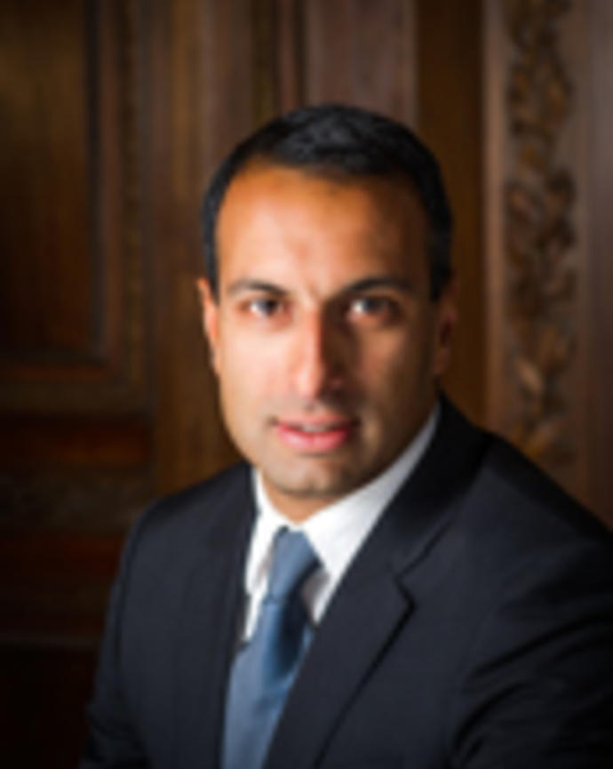 Vikram Kambampati has short black hair and is wearing a suit.