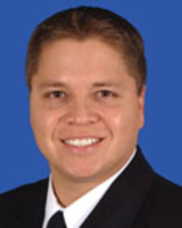 James Kennedye has short brown hair and is wearing a suit.