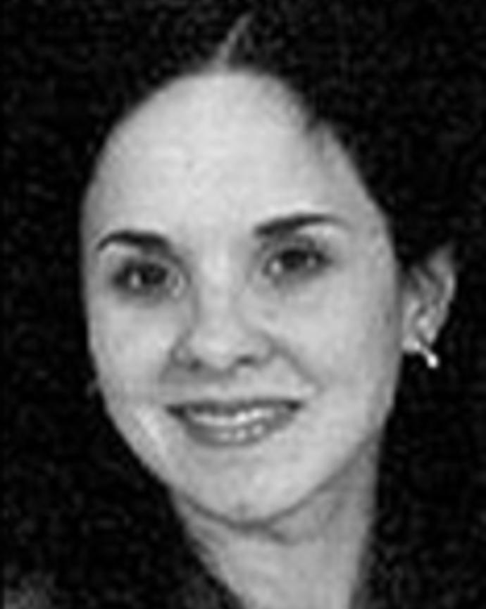 Claudia Martorell has black hair and is posed in front of a black background.