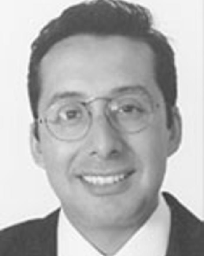 Adolfo Valadez has short dark hair and circular frame glasses.